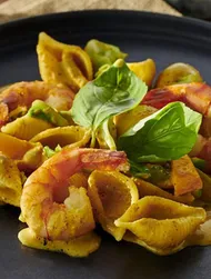 Conchiglie acompañado de gambas y verduras con salsa de curry y nata