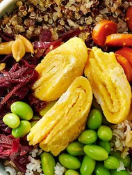 Bol caliente de arroz y quinoa con tortilla y cacahuetes