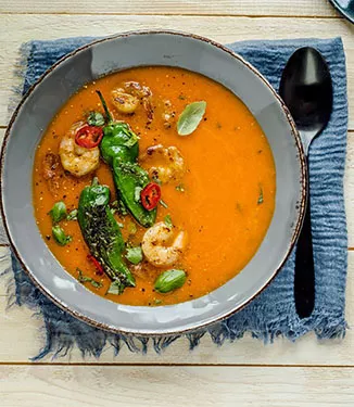 Puré cremoso de pimientos y tomate con langostinos teriyaki